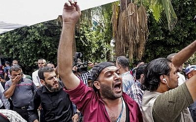 Des Palestiniens manifestent contre les réductions de postes annoncées par l'agence - plus de 250 - suite à la réduction des fonds versés par les Etats-Unis, au siège de l'agence à Gaza City, le 25 juillet 2018  (Crédit : SAID KHATIB / AFP)