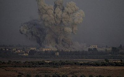 Une photo prise le 25 juillet 2018 depuis la colline Tal Saki sur les hauteurs du Golan montre de la fumée s'élevant au-dessus des bâtiments de l'autre côté de la frontière syrienne lors de frappes aériennes soutenant une offensive menée par le gouvernement syrien dans la province méridionale de Quneitra. (AFP / JALAA MAREY)