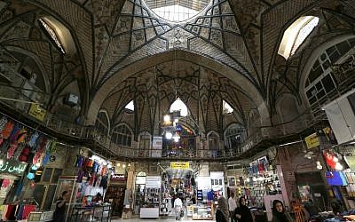 Des Iraniens déambulent dans l'ancien grand bazar de Téhéran, le 28 juillet 2018 (Crédit : / AFP PHOTO / ATTA KENARE)
