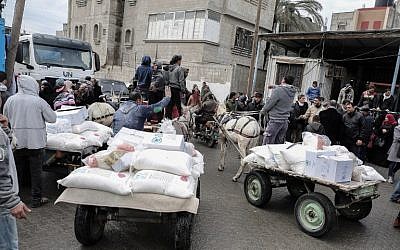 Des Palestiniens récupèrent des colis alimentaires fournis par les Nations unis, dans le sud de la bande de Gaza, le 28 janvier  2018. (Crédit : Said Khatib/AFP)