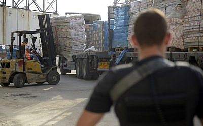 Illustration. Les agents du ministère de la Défense surveillent le transfert de fournitures et de marchandises dans la bande de Gaza par le point de passage de Kerem Shalom le 19 juillet 2014. (Armée israélienne)
