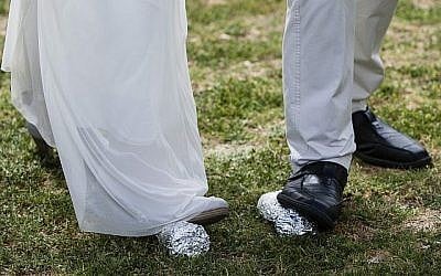 La mariée Lin Dror (G) et le marié Alon Marcus (D) cassent deux verres à la fin de leur cérémonie de mariage juif réformé célébré devant la Knesset, à Jérusalem, le 18 mars 2013, pour protester contre le monopole du Rabbinat orthodoxe sur les certificats de mariage et l'absence de mariages civils en Israël. (Flash 90)