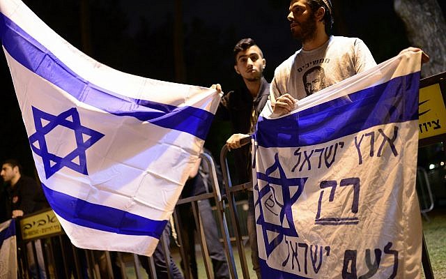 Des militants de droite israéliens protestent aux abords d'une cérémonie conjointe pour les familles de victimes israéliennes et palestiniennes lors de la Journée israélienne de commémoration, le 21 avril 2015 Le drapeau dit : "La terre d'Israël pour les Israéliens seulement" (Crédit : Tomer NeubergFlash90) Des militants de droite israéliens protestent aux abords d'une cérémonie conjointe pour les familles de victimes israéliennes et palestiniennes lors de la Journée israélienne de commémoration, le 21 avril 2015 Le drapeau dit : "La terre d'Israël pour les Israéliens seulement" (Crédit : Tomer NeubergFlash90)