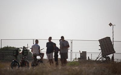 Des Israéliens regardent une batterie de défense antimissile du Dôme de fer dans le sud d'Israël, le 14 juillet 2018 (Crédit : Hadas Parush/Flash90)