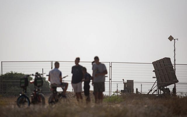 Des Israéliens regardent une batterie de défense antimissile du Dôme de fer dans le sud d'Israël, le 14 juillet 2018 (Crédit : Hadas Parush/Flash90)