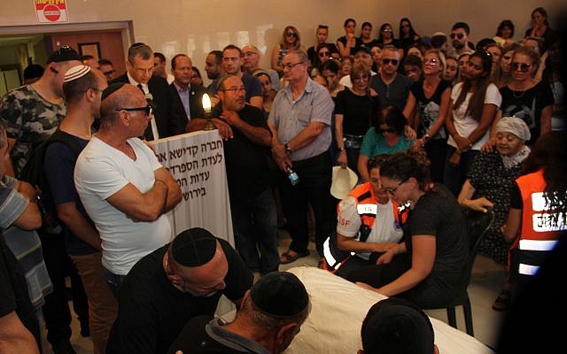 Des amis et des membres de la famille veillent la dépouille de Yotam Ovadia, 31 ans, le 27 juillet 2018. Ovadia a été assassiné près de chez lui dans l'implantation d'Adam lorsqu'un adolescent palestinien l'a poignardé et blessé deux autres Juifs lors d'une attaque terroriste le 26 juillet 2018. (Yonatan Sindel/Flash90) Des amis et des membres de la famille veillent la dépouille de Yotam Ovadia, 31 ans, le 27 juillet 2018. Ovadia a été assassiné près de chez lui dans l'implantation d'Adam lorsqu'un adolescent palestinien l'a poignardé et blessé deux autres Juifs lors d'une attaque terroriste le 26 juillet 2018. (Yonatan Sindel/Flash90)