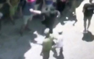 Capture d'écran d'un membre suisse de l'observatoire du PITH giflant un jeune Juif durant une visite de la ville de Hébron, en Cisjordanie, le 11 juin 2018 (Capture d'écran: Hadashot TV news)