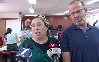 Nirit Zamoraà à gauche, parle aux journalistes dans la salle du tribunal militaire de Judée aux côtés de son mari avant la condamnation de son agresseur, le 16 juillet 2018 (Capture d'écran/Israel National News)