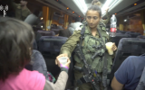 Des soldats de Tsahal donnent de l'eau aux secouristes de l'organisation "Casques Blancs" et à leurs familles, qu'Israël a acheminés de Syrie en Jordanie, alors qu'ils fuyaient le régime d'Assad, le 22 juillet 2018. (Armée israélienne)