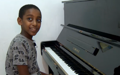 'Oshri Bitau, et son nouveau piano, dans sa maison de Nazareth Illit, le 15 juillet 2018. ( Crédit : capture d'écran Hadashot)