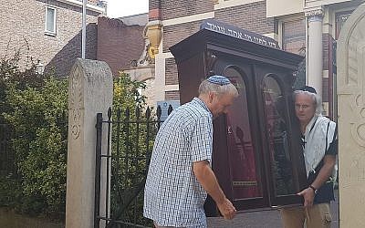 Tom Furstenberg, à droite, et membre de la communauté juive de Deventer transporte une arche à Torah hors de l'ancienne synagogue qu'il s'apprête à quitter, le 30 juillet 2018  Crédit : Cnaan Liphshiz/JTA)