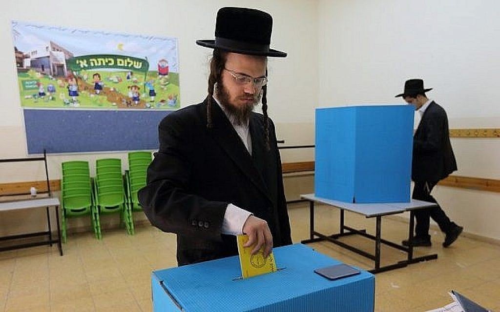 Un ultra-orthodoxe met son bulletin dans l'urne dans un bureau de vote durant les élections municipales israéliennes, le 22 octobre 2013 (Crédit :  Yaakov Naumi/Flash90)