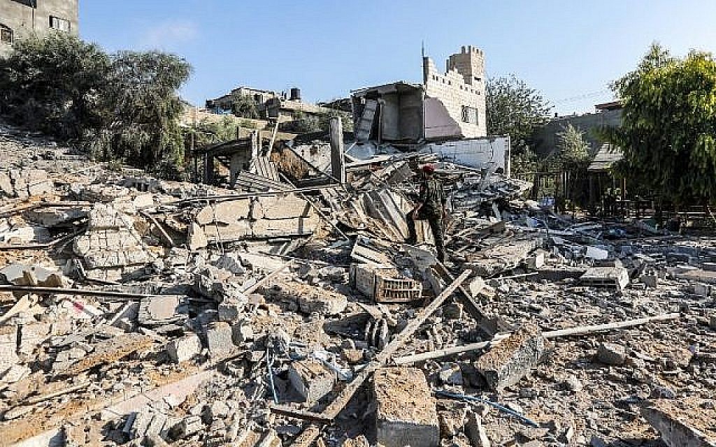 Un membre du Hamas traverse les décombres d'un site touché par des frappes aériennes israéliennes dans la ville de Gaza, le 9 août 2018 (Crédit : AFP / MAHMUD HAMS)