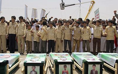 Des enfants yéménites expriment leur colère contre Ryad et Washigton, le 13 août 2018, alors qu'ils participent à des funérailles de masse dans la ville du nord du Yémen  de  Saada, bastion des Houthis, soutenus par l'Iran, pour les enfants morts lors d'une frappe aérienne dirigée par les Saoudiens (Crédit : / AFP PHOTO / STRINGER)