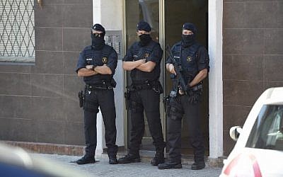 La police régionale de Catalogue monte la garde devant l'immeuble où vit un homme qui à tenté d'attaquer un poste de police, à Barcelone, le 20 août 2018. (Crédit : AFP/LLUIS GENE)