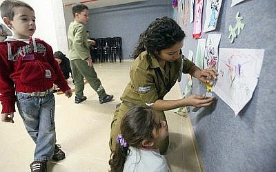 Illustration d' un soldat de l'armée israélienne jouant avec des enfants dans un abri anti-aérien dans le sud d'Israël en novembre 2012. (Miriam Alster / Flash 90)