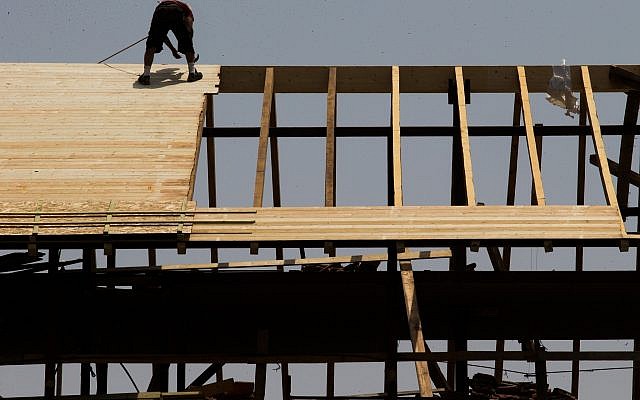 Un ouvrier travaille sur un toit d'un chantier de construction à Jérusalem, le 5 août 2015 (Nati Shohat/Flash90). Un ouvrier travaille sur un toit d'un chantier de construction à Jérusalem, le 5 août 2015 (Nati Shohat/Flash90).