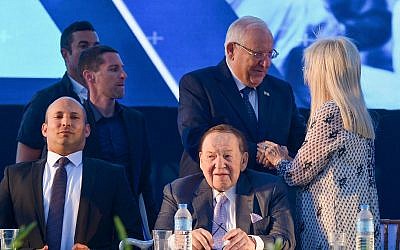 L'homme d'affaires et investisseur Sheldon Adelson, assis sur la droite, son épouse  Miriam avec le président Reuven Rivlin , débout, au milieu, et le ministre de l'Education Naftali Bennett, à gauche, lors de l'inauguration de la faculté de médecine de l'université d'Ariel en Cisjordanie, le 19 août 2018 (Crédit :Ben Dori/Flash90)