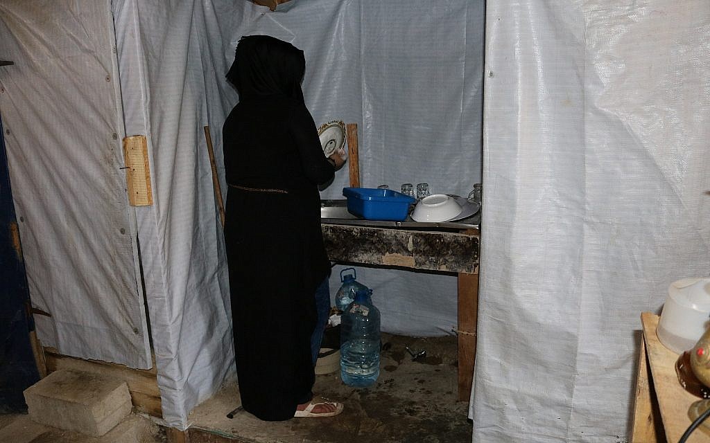 Suzanne Farrah fait la vaisselle dans la maison de sa famille. Comme Halima, elle est conspuée pour avoir quitté son époux et quitte peu la tente (Crédit : Lisa Khoury/ Times of Israel)