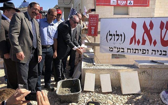 L'ancien gouverneur de l'Arkansas Mike Huckabee posant des briques lors d'une cérémonie organisée dans un nouveau complexe résidentiel au sein de l'implantation d'Efrat, en Cisjordanie, le 1er août 2018. (Crédit : Jacob Magid/Times of Israel) L'ancien gouverneur de l'Arkansas Mike Huckabee posant des briques lors d'une cérémonie organisée dans un nouveau complexe résidentiel au sein de l'implantation d'Efrat, en Cisjordanie, le 1er août 2018. (Crédit : Jacob Magid/Times of Israel)