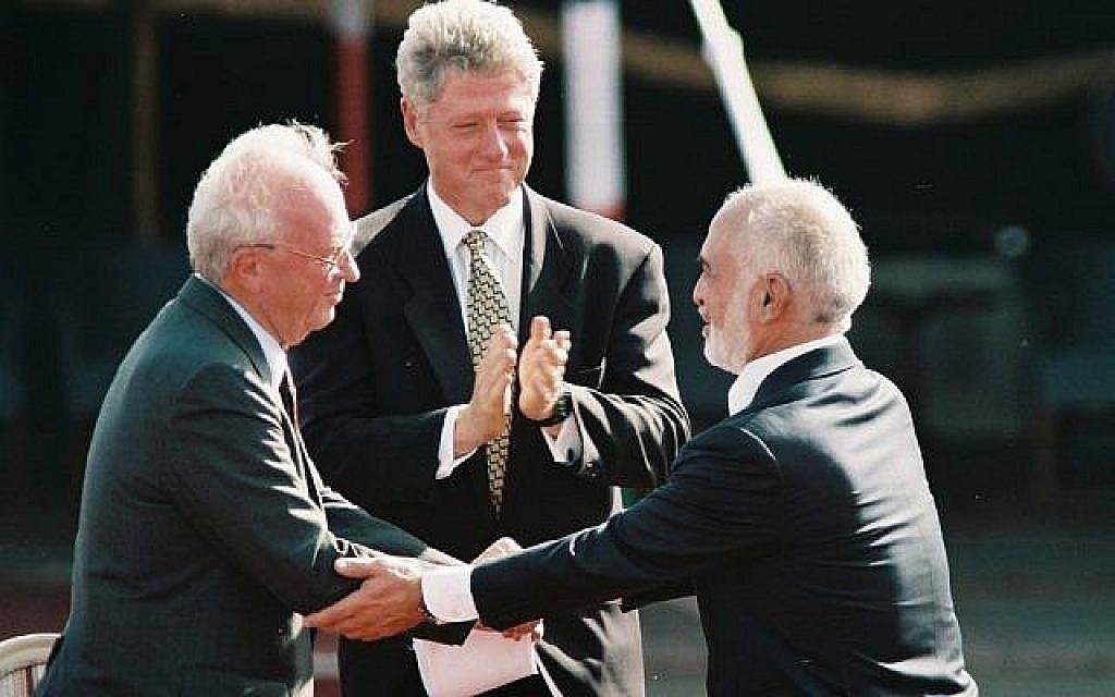 Le Premier ministre israélien Yitzhak Rabin (à gauche) serre la main du roi Hussein de Jordanie sous les applaudissements du président des Etats-Unis Bill Clinton lors de la signature du traité de paix bilatéral, à Aqaba, Jordanie, en octobre 1994. (Nati Shohat/Flash90)