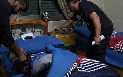La police fouille le domicile d'un suspect dans une affaire de rémunérations illégales des services offerts par les bureaux du ministère de l'Intérieur à Jérusalem-Est (Crédit : Police israélienne)