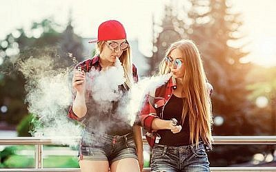 Image illustrative de deux femmes en train de vapoter à l'extérieur. (iStock par Getty Images/licsiren)