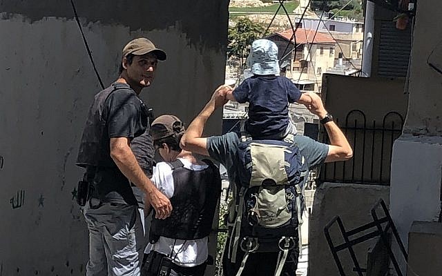 Des gardes de sécurité privés financés par l'Etat escortant une famille juive à la maison Beit Rachel, appartenant à Ateret Cohanim dans le quartier de Batan al-Hawa de Silwan, à Jérusalem Est, le 31 juillet 2018 (Crédit : Sue Surkes/Times of Israel.)