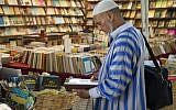 Un client consulte des livres dans une librairie de la capitale marocaine de Rabat, le 9 août 2018. Sur les principales artères du vieux Rabat, des dizaines de libraires itinérants proposent des livres en français, en arabe et parfois en anglais, jusqu'à dix fois moins chers que leurs originaux. (AFP PHOTO / FADEL SENNA)