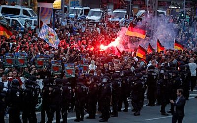 Des manifestants de droite allument des fusées le 27 août 2018 à Chemnitz, dans l'est de l'Allemagne, suite à la mort d'un Allemand de 35 ans qui aurait été tués par deux migrants du monde musulman (Crédit : AFP Photo/Odd Andersen)