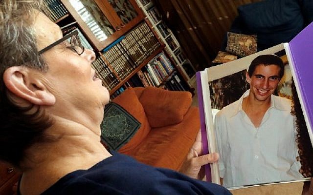 Leah Goldin (L), the mother of Israeli soldier Lieutenant Hadar Goldin, holds up a picture of her son as she speaks during an interview with AFP at their family home in the central Israeli city of Kfar Saba on August 29, 2018.
From the living room of their home in central Israel, surrounded by books and family photos, Leah and Simha Goldin have waged a years-long campaign to bring back the remains of their son, Lieutenant Hadar Goldin, a soldier killed in the 2014 Gaza war, and whose body is believed to be held by Hamas. / AFP PHOTO / JACK GUEZ