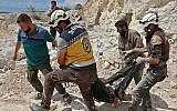 A Kafr Ain, des membres de la Défense civile syrienne, connus sous le nom de Casques blancs, transportent une victime après des frappes aériennes à 4 kilomètres à l'est de Khan Shaykhun idans le sud de la province d'Dlib, le 7 septembre 2018 (Crédit : AFP PHOTO / Anas AL-DYAB)
