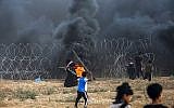 Un jeune Palestinien utilise une fronde pour jeter des pierres aux forces israéliennes durant des affrontements à la frontière entre Israël et la bande de Gaza, à l'est de Gaza city, le 7 septembre 2018 (Crédit : AFP/Said Khatib)