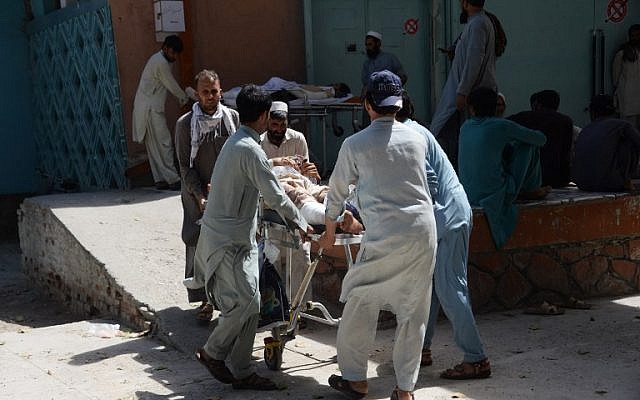Des volontaires et des parents afghans transportent une victime blessée sur une civière pour qu'elle reçoive des soins médicaux au Pakistan le lendemain d'un attentat-suicide visant des manifestants dans le district de Mohmand Dara de la province de Nangarhar, à Jalalalabad, le 12 septembre 2018. (AFP PHOTO / NOORULLAH SHIRZADA)