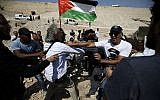 Les forces de sécurité israéliennes se bagarrent avec le manifestant franco-américain Frank Romano, le 14 septembre 2018, durant une manifestation contre la destruction du village bédouin de Khan al-Ahmar, en Cisjordanie (Crédit : AFP PHOTO / ABBAS MOMANI)