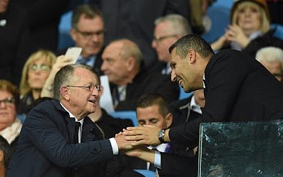 Le président lyonnais Jean-Michel Aulas (à gauche) accueille Khaldoon Al Mubarak, président de Manchester City, avant le match de football du groupe F de l'UEFA Champions League entre Manchester City et Lyon au stade Etihad à Manchester, au nord-ouest de l'Angleterre, le 19 septembre 2018. (AFP PHOTO / Oli SCARFF)