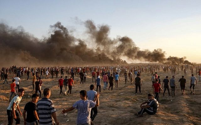 Des manifestants palestiniens rassemblés le long de la barrière frontalière israélienne à l'est de la ville de Gaza, alors que de la fumée émane de pneus, le 21 septembre 2018. (AFP / Said Khatib) Des manifestants palestiniens rassemblés le long de la barrière frontalière israélienne à l'est de la ville de Gaza, alors que de la fumée émane de pneus, le 21 septembre 2018. (AFP / Said Khatib)