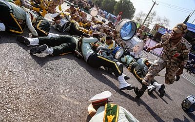 Un soldat iranien court devant ses collègues blessés, au sol, lors d'une attaque contre une parade militaire à Ahvaz, le 22 septembre 2018 (Crédit : AFP/ ISNA / MORTEZA JABERIAN)