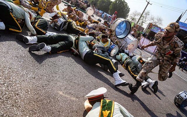 Un soldat iranien court devant ses collègues blessés, au sol, lors d'une attaque contre une parade militaire à Ahvaz, le 22 septembre 2018 (Crédit : AFP/ ISNA / MORTEZA JABERIAN) Un soldat iranien court devant ses collègues blessés, au sol, lors d'une attaque contre une parade militaire à Ahvaz, le 22 septembre 2018 (Crédit : AFP/ ISNA / MORTEZA JABERIAN)