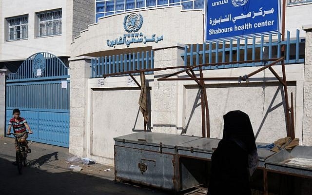Illustration : une Palestinienne marche à côté d'un centre de santé fermé de l'UNRWA, l'agence chargée de l'aide aux réfugiés palestiniens de l'ONU, au cours d'une grève des institutions de l'UNRWA à Rafah, dans le sud de la bande de Gaza, le 24 septembre 2018 (Crédit : AFP/Said Khatib) Illustration : une Palestinienne marche à côté d'un centre de santé fermé de l'UNRWA, l'agence chargée de l'aide aux réfugiés palestiniens de l'ONU, au cours d'une grève des institutions de l'UNRWA à Rafah, dans le sud de la bande de Gaza, le 24 septembre 2018 (Crédit : AFP/Said Khatib)