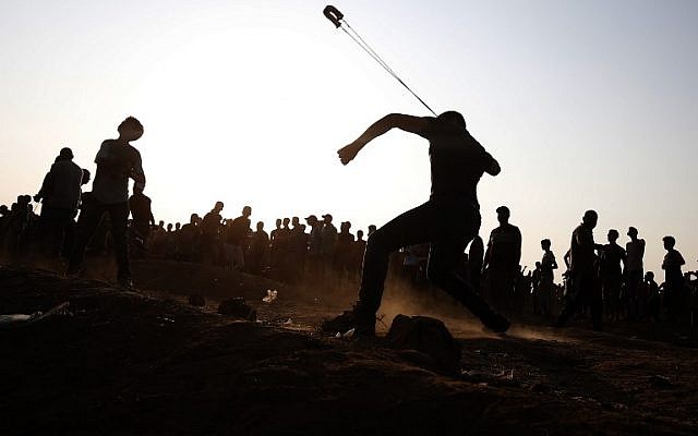 Un manifestant palestinien jette une pierre vers les soldats israéliens pendant des affrontements le long de la frontière de Gaza, le 28 septembre 2018 (Crédit :. / AFP PHOTO / Said KHATIB) Un manifestant palestinien jette une pierre vers les soldats israéliens pendant des affrontements le long de la frontière de Gaza, le 28 septembre 2018 (Crédit :. / AFP PHOTO / Said KHATIB)