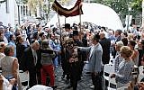 Le rabbin Asher Faith transporte un rouleau de Torah tout juste consacré pour la congrégation, lors de la consécration de l'espace de prière de la synagogue médiévale de Budapest, le 6 septembre 2018 (Crédit : Márton Merész)