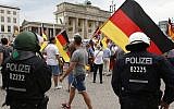 Des partisans de l'AfD allemande brandissent des drapeaux devant la porte de Brandenburg à Berlin, en Allemagne, le 27 mai 2018 (Crédit : AP Photo/Michael Sohn)