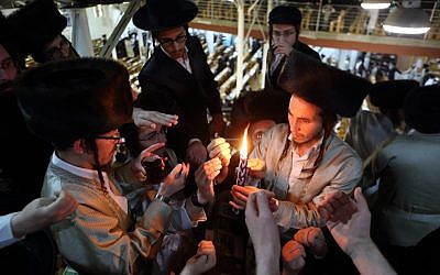 Des ultra-orthodoxes allument la bougie de la "Havdalah"  qui marque la fin du Shabbat juif dans une synagogue d'Ouman, en Ukraine, pendant la fête juive de Rosh HaShana, le 7 septembre 2013. (Crédit : Yaakov Naumi/Flash90)
