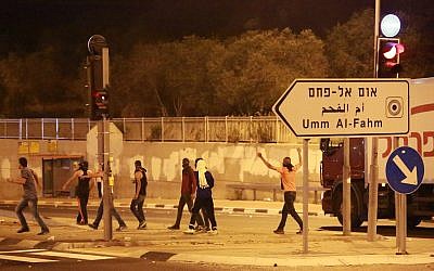 Des manifestants jettent des pierres aux forces de sécurité israéliennes, non visibles, à Umm el Fahm, le 5 juillet 2014 (Crédit :Omar Samir/FLASH90)