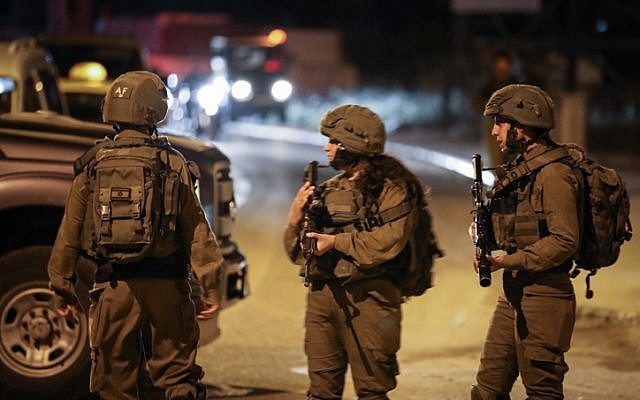 Les soldats israéliens aux abords de la scène d'un attentat terroriste à l'entrée de Housan, en Cisjordanie, le 23 juin 2018 (Crédit :  Nati Shohat/Flash90)
