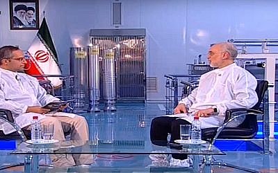 Capture d'écran d'une séquence vidéo d'Ali Akbar Salehi, chef de l'agence nucléaire iranienne, (à droite) et de trois centrifugeuses d'enrichissement en uranium en arrière plan. (Crédit : YouTube)