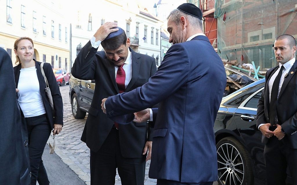 Le président hongrois Janos Ader met une kippa lors de la consécration de l'espace de prière de la synagogue médiévale à Budapest, le 6 septembre 2018 (Crédit : Márton Merész)
