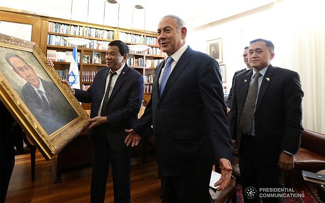 Le président des Philippines, Rodrigo Duterte, offre au Premier ministre israélien Netanyahu un tableau de lui-même avant une rencontre bilatérale entre les Philippines et Israël au bureau du Premier ministre à Jérusalem, le 3 septembre 2018. (King Rodriguez/photo présidentielle) Le président des Philippines, Rodrigo Duterte, offre au Premier ministre israélien Netanyahu un tableau de lui-même avant une rencontre bilatérale entre les Philippines et Israël au bureau du Premier ministre à Jérusalem, le 3 septembre 2018. (King Rodriguez/photo présidentielle)