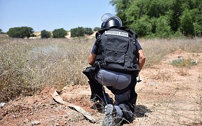 Un sapeur de la police désarme un dispositif explosif aérien qui a atterri dans la ville de   Kiryat Gat, au sud d'Israël, le 14 septembre 2018 (Crédit : Police israélienne)